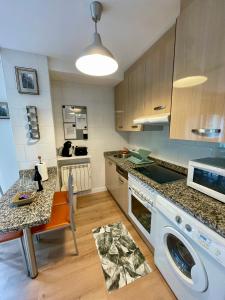 a kitchen with a washing machine and a table at Can Rios-Felechosa - Aller in Felechosa