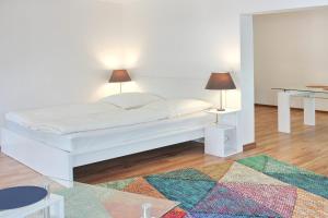 a white bed with two lamps on two tables at Lilie in Lübbenau