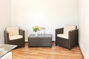 two chairs and a table with a vase of flowers at Lilie in Lübbenau