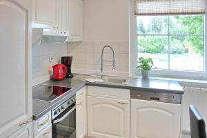 a kitchen with white cabinets and a sink at Lilie in Lübbenau
