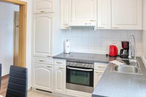 a kitchen with white cabinets and a stove top oven at Lilie in Lübbenau +11 photos