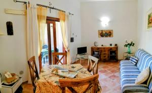 a living room with a table and a couch at Grazioso appartamento con tutti confort in Lu Lioni