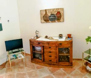 a living room with a wooden table and a chair at Grazioso appartamento con tutti confort in Lu Lioni