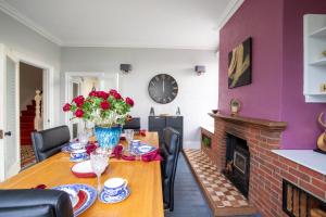 a dining room with a table and a fireplace at Group Accommodation - Rushden A6 Manor House - Private Gated -Sleeps 15 - Secure Parking in Rushden