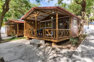 a small cabin with a porch and a deck at Bungalows & Glamping Conil Playa in Conil de la Frontera