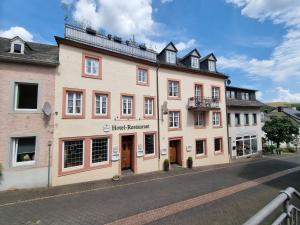 a large pink building on the side of a street at Hotel Haus Irsfeld in Waxweiler