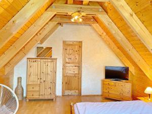 a living room with a tv and a wooden ceiling at Eisvogel in Lübbenau