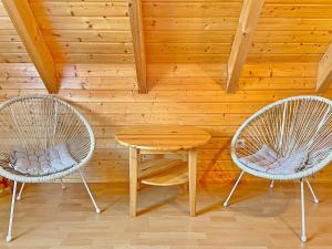 two chairs and a table in a room with a wooden wall at Eisvogel in Lübbenau