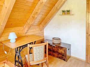 a wooden room with a desk and a table and chairs at Eisvogel in Lübbenau