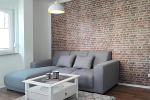 a living room with a couch and a brick wall at Dobra in Lübbenau