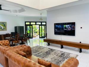 a living room with a couch and a flat screen tv at Ornella Villa in Yogyakarta