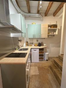 a kitchen with blue cabinets and a sink at Chez Fabienne Maison Fontvieille in Fontvieille