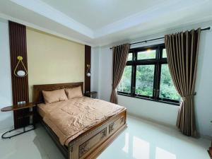 a bedroom with a bed and a large window at Ornella Villa in Yogyakarta