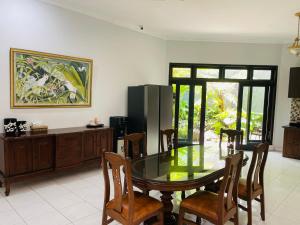 a dining room with a table and chairs and a refrigerator at Ornella Villa in Yogyakarta