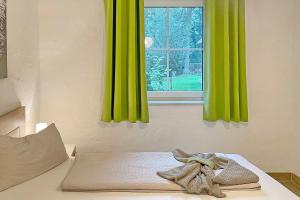 a bed with green curtains and a window at Laubhütte Baum 1 in Burg +14 photos