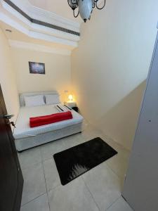 a bedroom with a bed and a black rug at Deira Guest house by PHM in Dubai