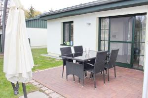 a patio with a table and chairs and a umbrella at Quartier Spreestraße - App 4 in Burg