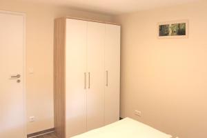 a bedroom with a white cabinet and a bed at Quartier Spreestraße - App 4 in Burg +5 photos