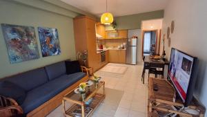 a living room with a blue couch and a kitchen at SweetHome Komotini central & comfy apartment with Parking in Komotini