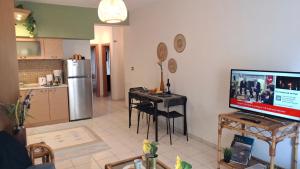 a kitchen and a living room with a table and a television at SweetHome Komotini central & comfy apartment with Parking in Komotini