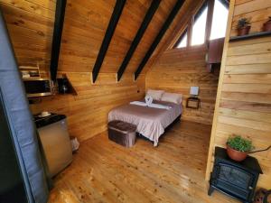 a bedroom in a log cabin with a bed and a fireplace at Brisas De Los Santos Lodge 1 in Sierra