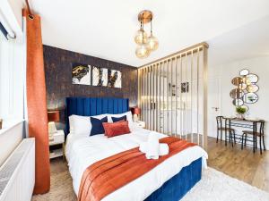 a bedroom with a large bed with a blue headboard at The Cosy Retreat in Droitwich +24 photos