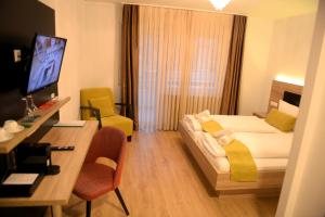 a hotel room with a bed and a desk with a computer at Hotel zur Flüh in Bad Säckingen