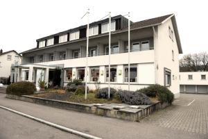 a large white building on the side of a street at Hotel zur Flüh in Bad Säckingen