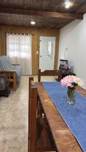 a living room with a table with a vase of flowers at Cabaña la Relajación in San Miguel del Monte