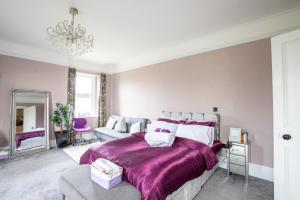 a bedroom with a large bed with a purple blanket at Group Accommodation - Rushden A6 Manor House - Private Gated -Sleeps 15 - Secure Parking in Rushden