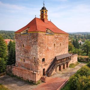 ein großes Backsteingebäude mit einem Turm darauf in der Unterkunft Pension Bertuch in Peitz
