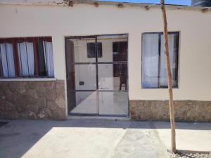 a building with glass doors and a tree in front at Cabaña Sal y Piedra in Uyuni +23 photos