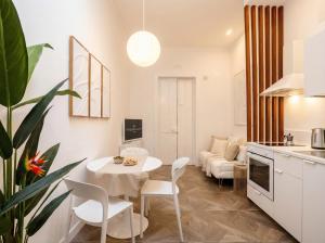 a kitchen and a living room with a table and chairs at Sfazion - Central Apartment in Bari