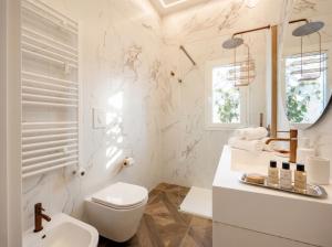 a white bathroom with a toilet and a sink at Sfazion - Central Apartment in Bari +13 photos