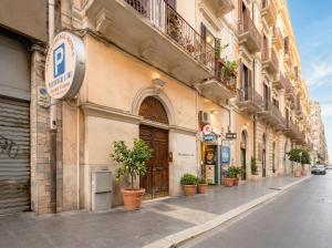 a building with potted plants on the side of a street at Sfazion - Central Apartment in Bari