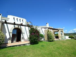 Biały dom z werandą i dziedzińcem w obiekcie Belvilla by OYO Vista Blu Resort Villa Otto Pax w mieście Alghero