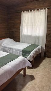 a bedroom with two beds and a window at Cabaña la Relajación in San Miguel del Monte