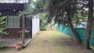 a yard with a fence and a tree at Cabaña la Relajación in San Miguel del Monte