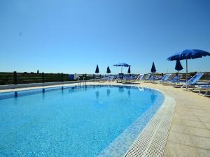 duży basen z leżakami i parasolami w obiekcie Belvilla by OYO Vista Blu Resort Villa Otto Pax w mieście Alghero
