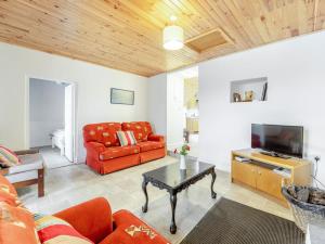 a living room with a red couch and a tv at 3 Bed in Roundstone oc-i234 in Callow