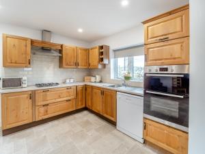 a kitchen with wooden cabinets and white appliances at 3 Bed in Roundstone oc-i234 in Callow +17 photos