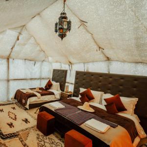 a room with two beds in a tent at Overnight Luxury Camp in Merzouga