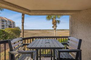 a picnic table on a porch with a view of a field at 201 Captains Quarters in Hilton Head Island