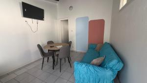 a living room with a blue couch and a table at Le lis de Udol in Pointe-à-Pitre
