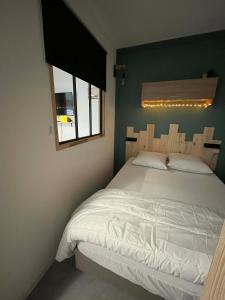 a bedroom with a white bed and a window at L'ourson B2 in La Bresse