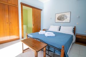 ein Schlafzimmer mit einem blauen Bett, auf dem Handtücher liegen in der Unterkunft Artiki's Studios - Sea & Harbour View Apartments in Symi in Symi