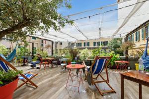 an outdoor patio with chairs and tables and awnings at Hotel Britannia in Genoa