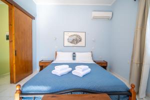 ein Schlafzimmer mit einem Bett, auf dem zwei Handtücher liegen in der Unterkunft Artiki's Studios - Sea & Harbour View Apartments in Symi in Symi + 59 Fotos