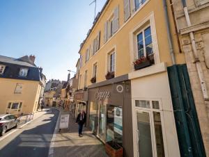 a woman walking down a street in front of a store at "Le Majorelle" logement atypique en hyper centre ville de Nevers, avec service premium in Nevers