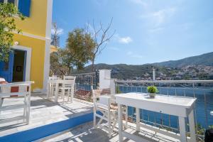 ein Balkon mit Tisch und Stühlen und dem Wasser in der Unterkunft Artiki's Studios - Sea & Harbour View Apartments in Symi in Symi